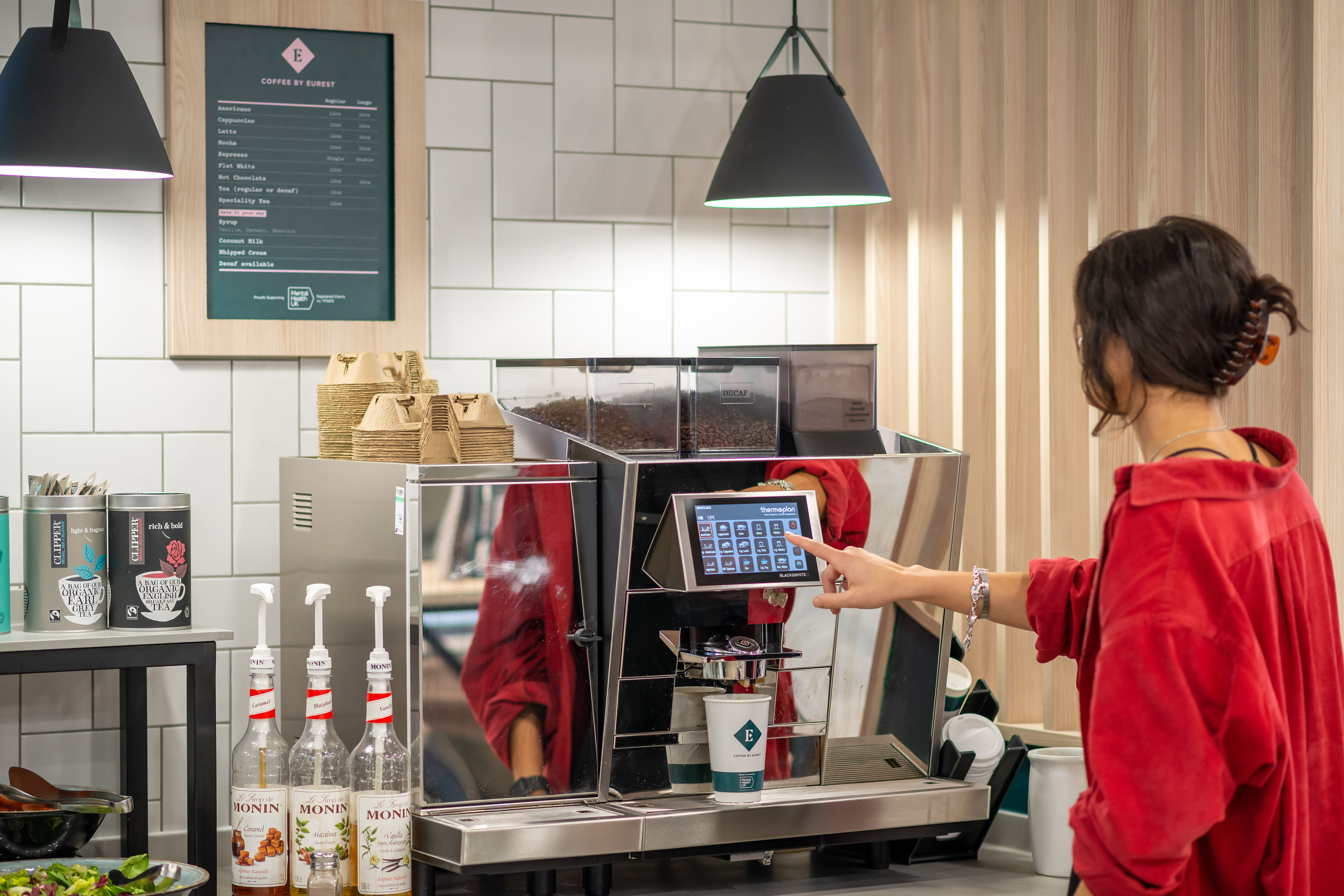 an employee making coffee with through a foodservices